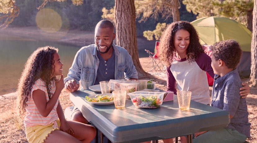 People gathered around a table, eating al fresco