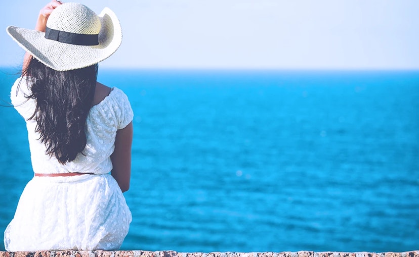 Woman sitting on the beach enjoying a vacation