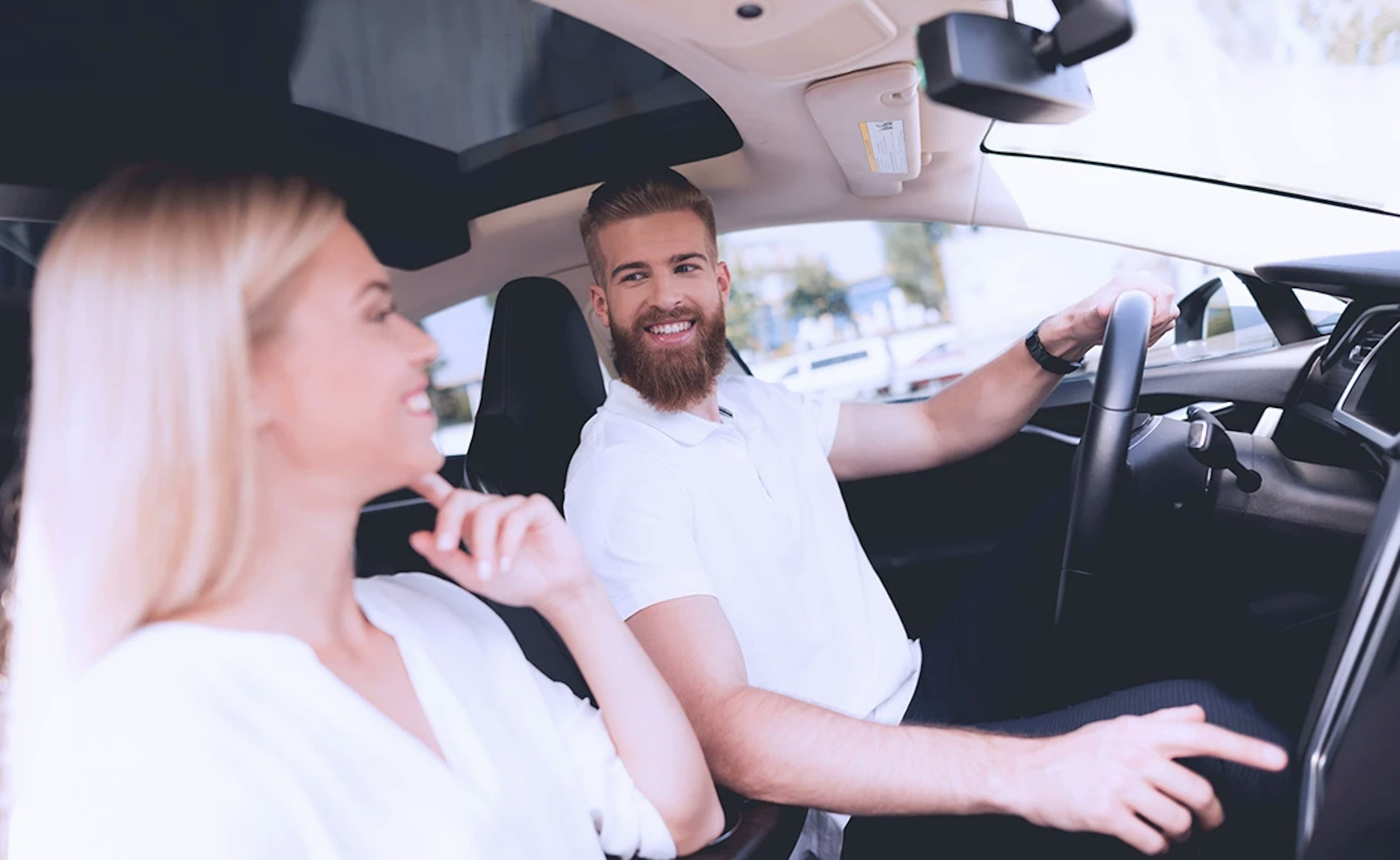 Uber driver picks up a woman in a scheduled Uber car. They both wear white shirts.