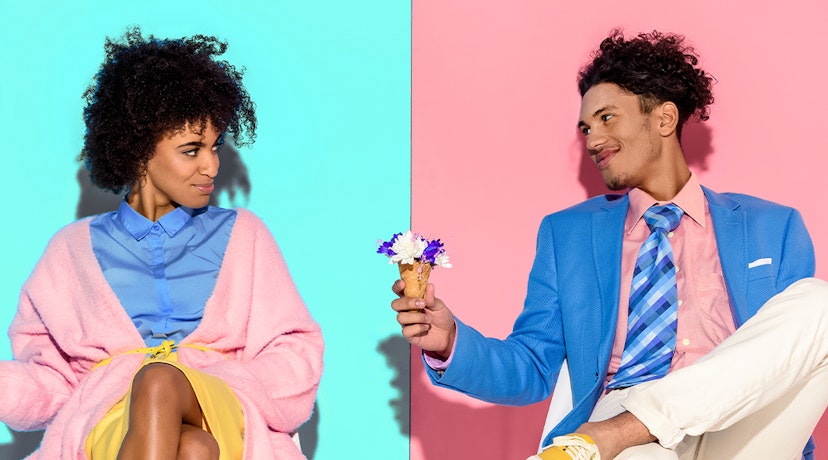 A man holds out a small bouquet of flowers to a woman