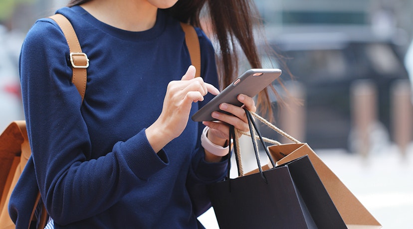 Woman using Ibotta's text alert service to get updates and save even more money.