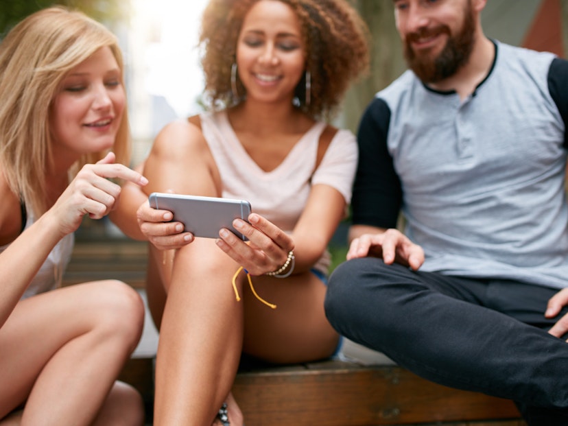 three people look at 1 smart phone for cash back