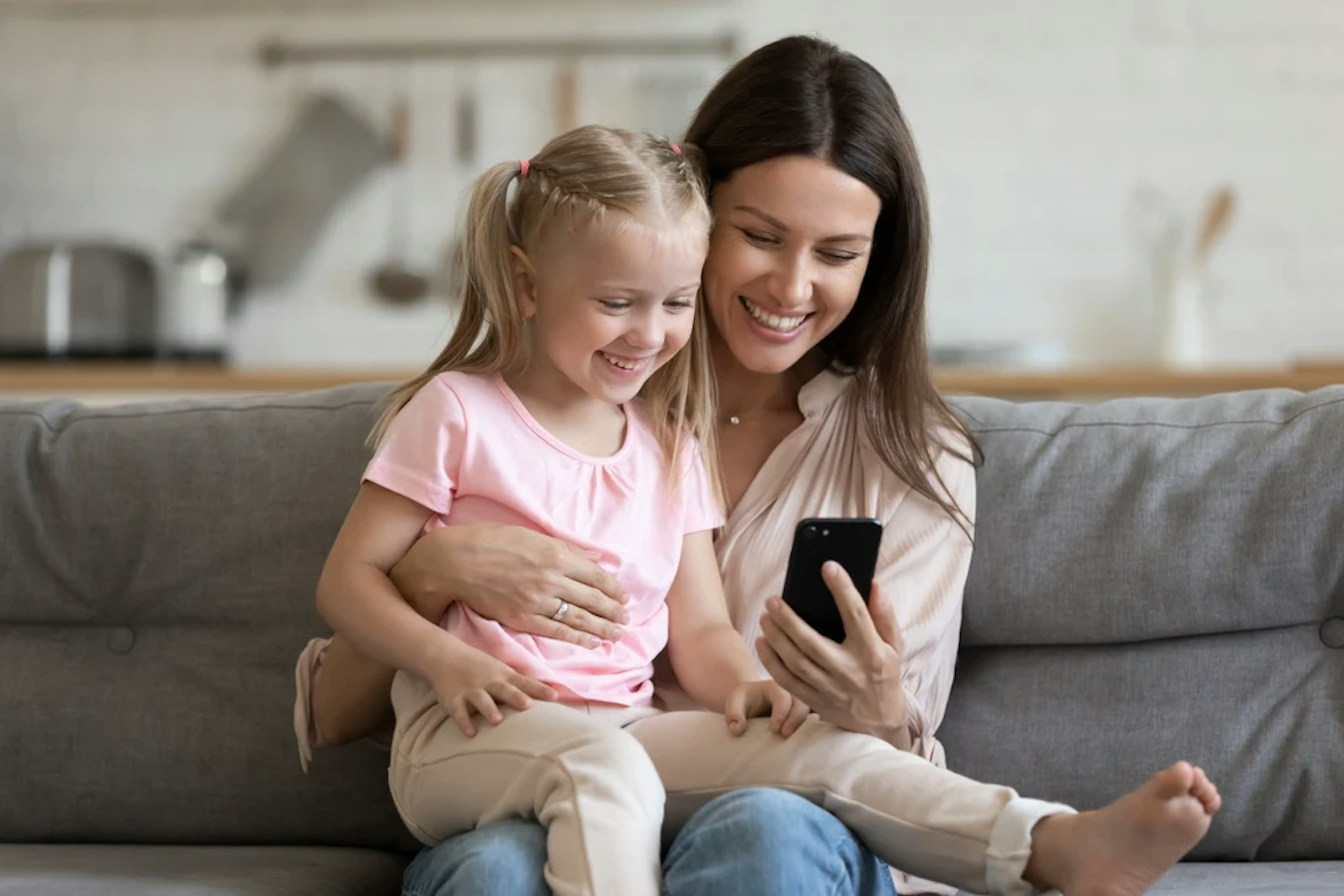 Woman with daughter earning cash back on their phone with Ibotta