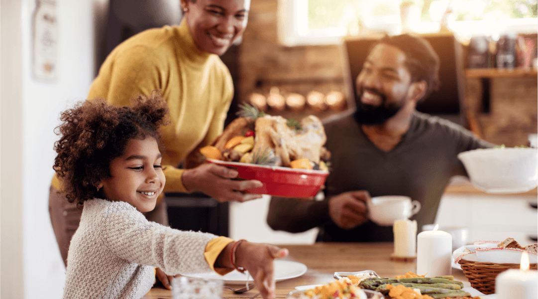 A family sits around a holiday table full of food